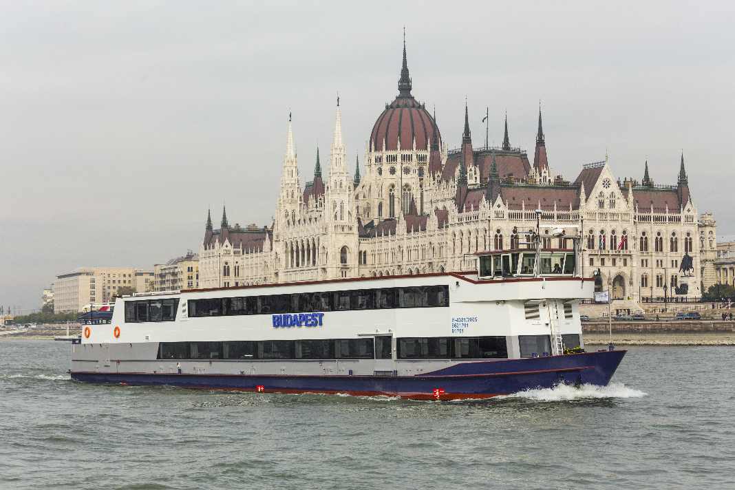 boat floating on the Danube river, passing by the Hungarian parliament